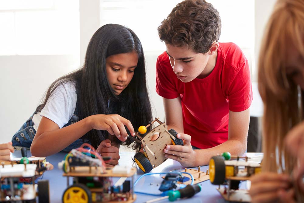 Two Teenagers Playing together, Building And Learning To Program Robot Vehicle